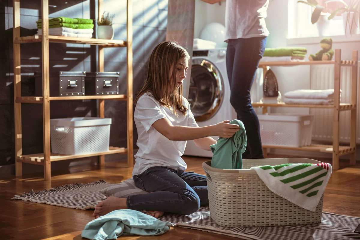 Daughter helping mother organizing the laundry room