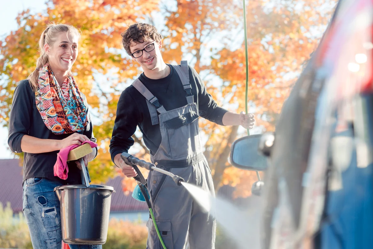 Smiling Couple Cleaning Car In The Fall