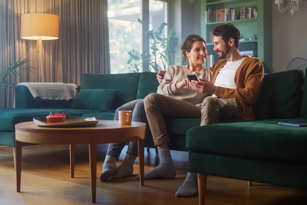 Couple talking on a couch in cozy apartment