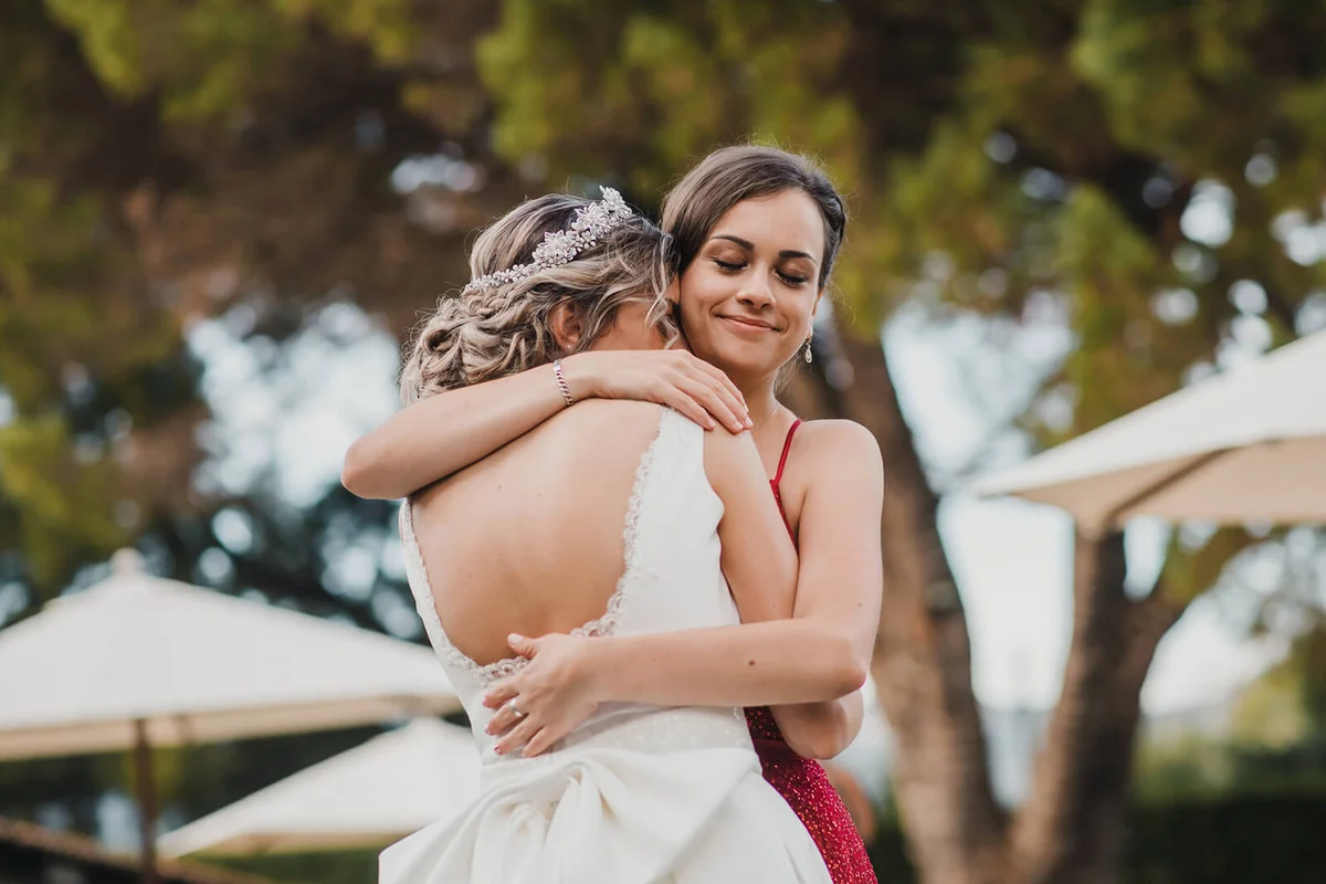 Sisters embracing on wedding day