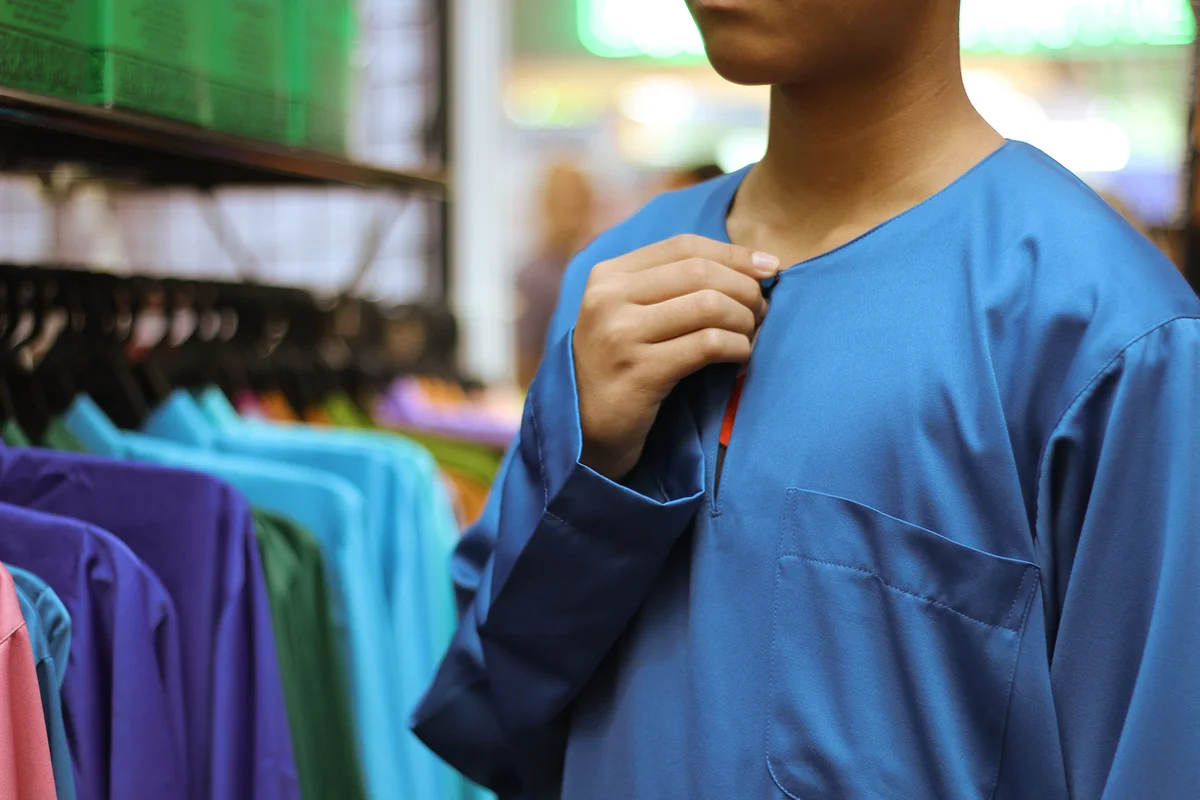 Boy Trying on Blue Shirt In Shop