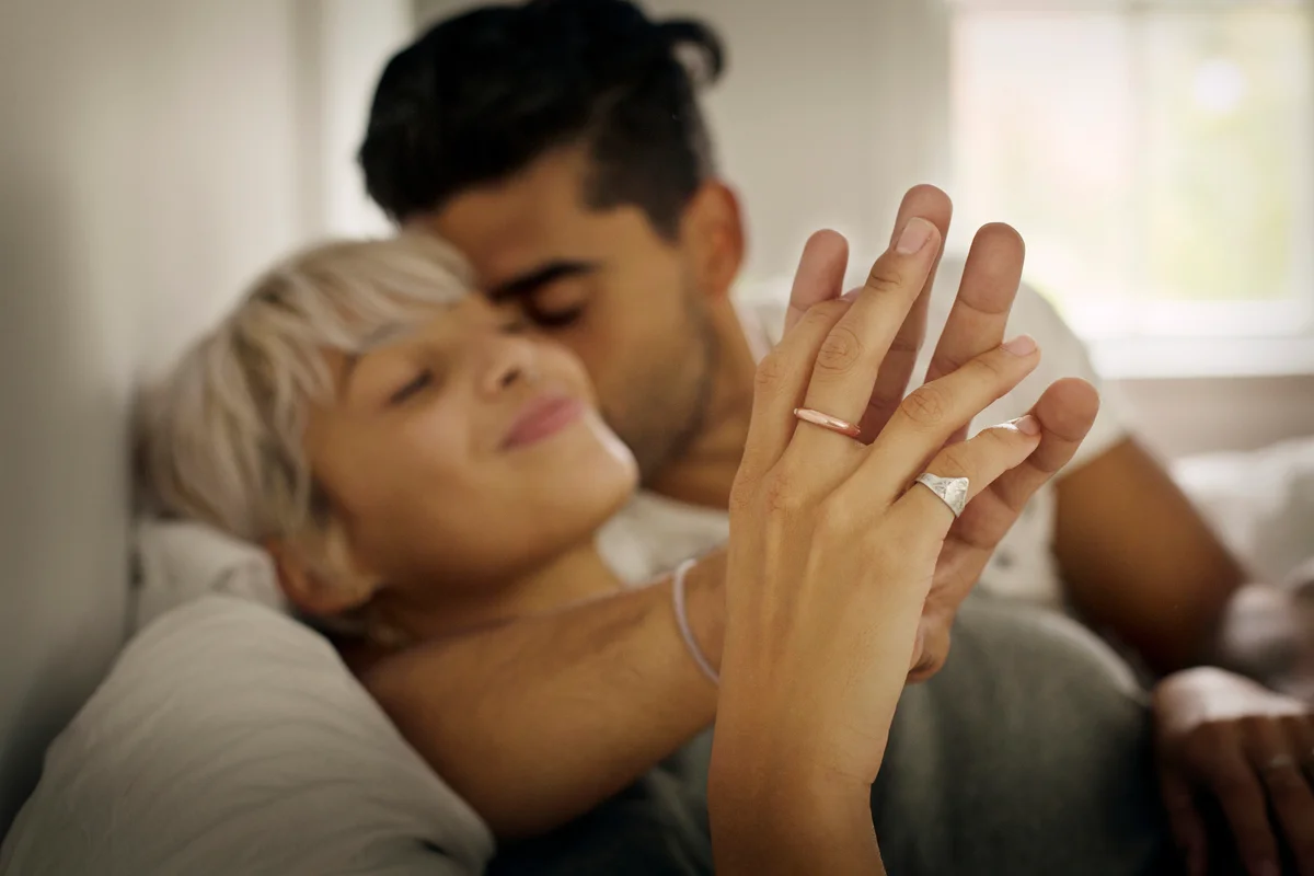 young man kissing woman while holding hand