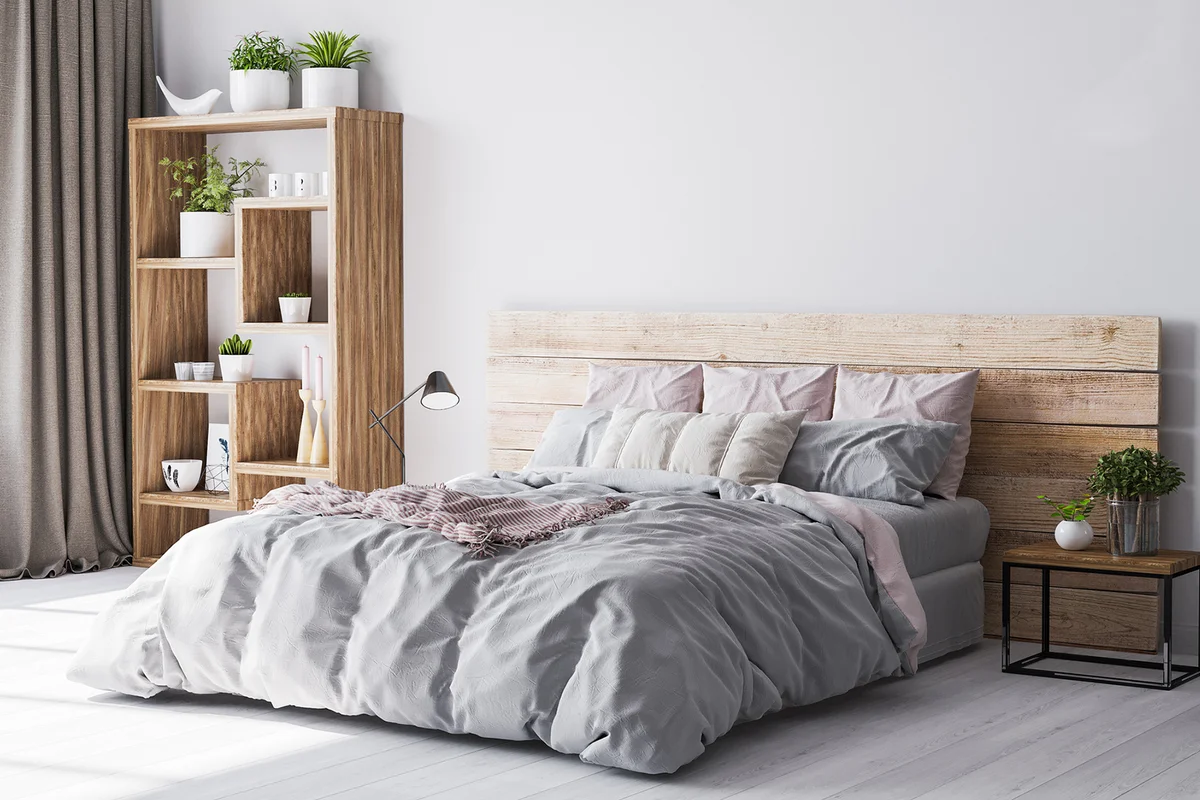 Cozy bedroom area at wooden apartment with wooden comfy bed and green plants.