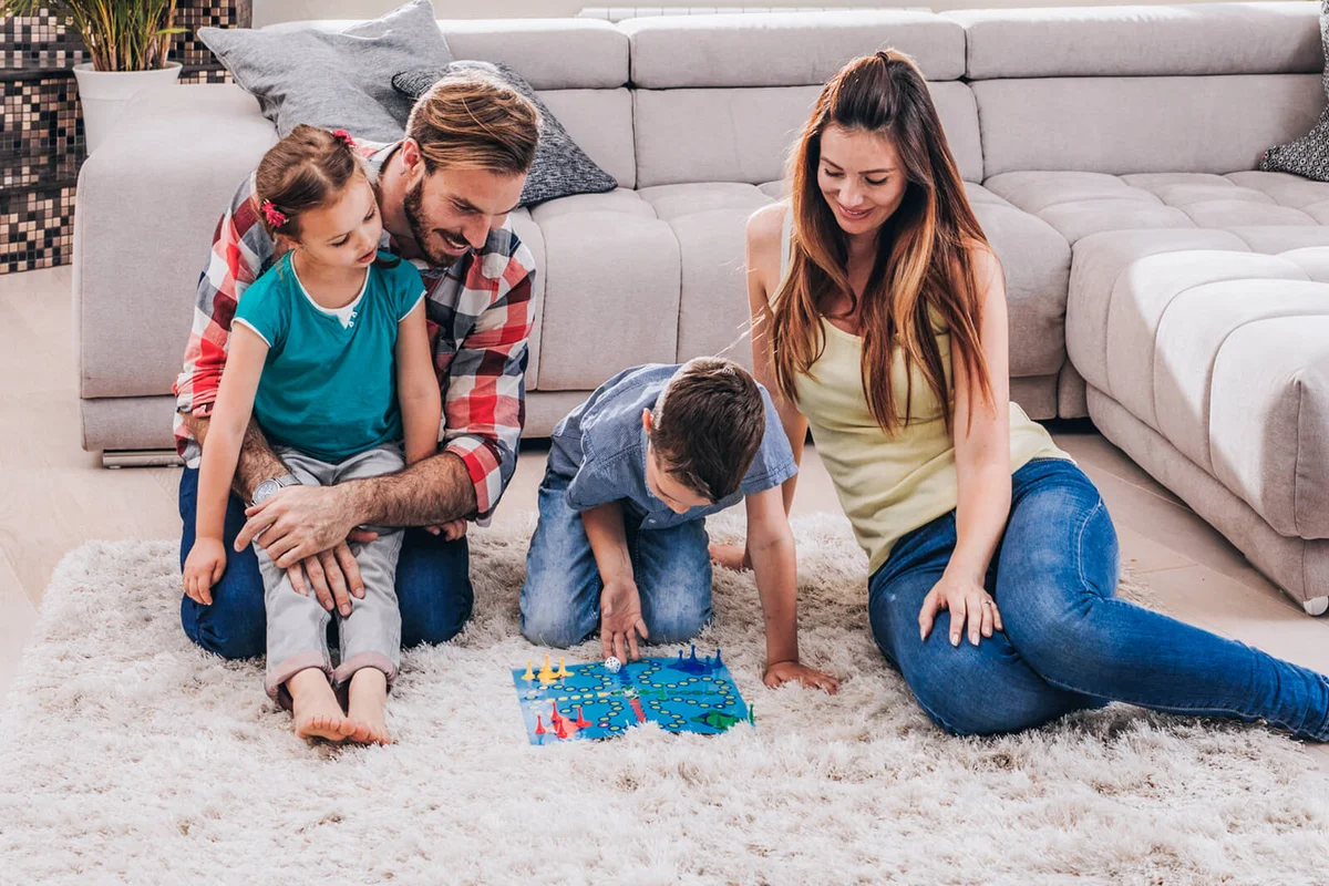 young family playing cross and section game on the floor at their penthouse