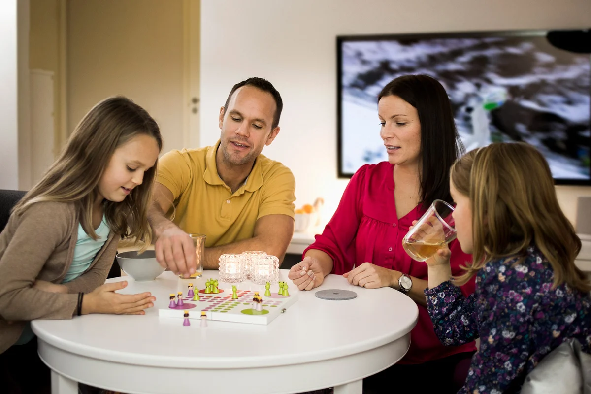 Family playing ludo in living room