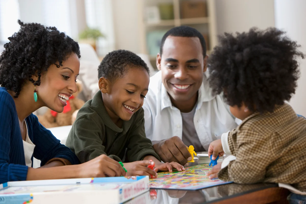 African American family playing Candyland board game together