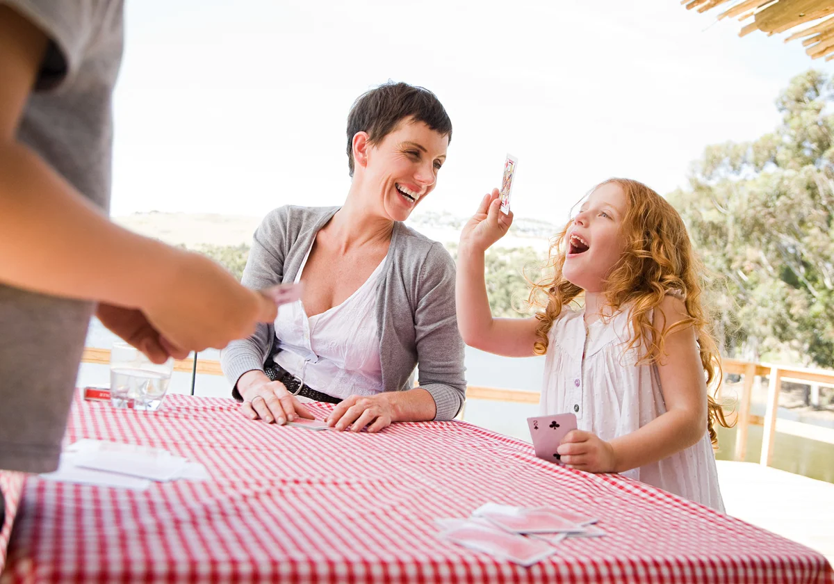 Girl playing Old Maid card game with mother