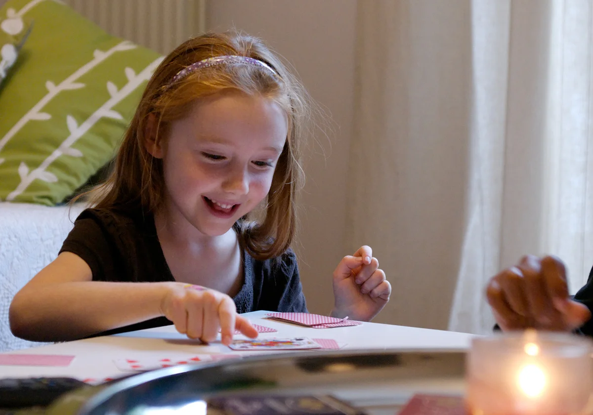Young girl playing game of War with cards