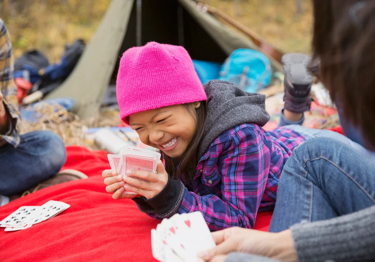 Family playing Snap Card Game at campsite