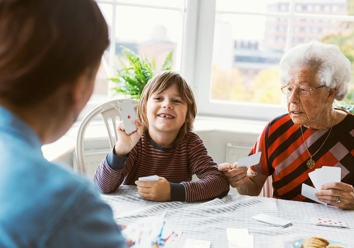 Boy playing Scat card game with mother and great grandmother