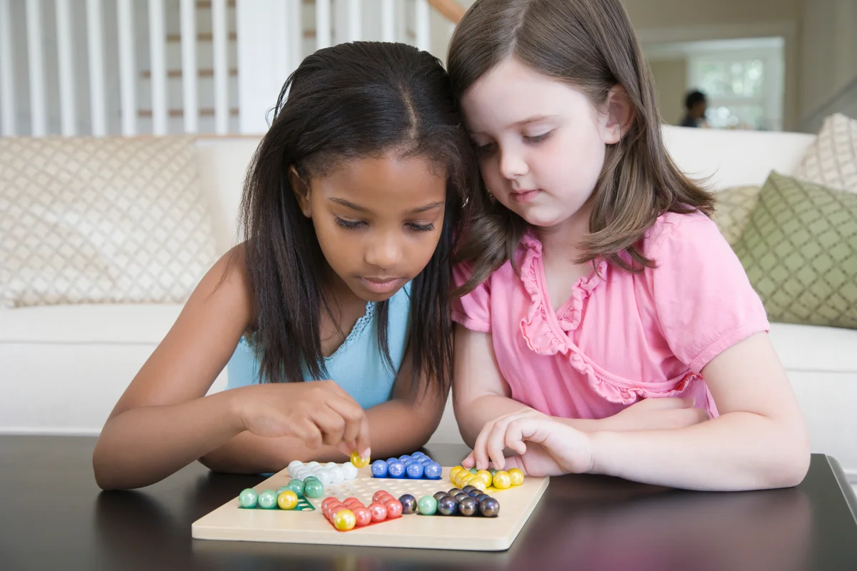 Two girls playing Chinese checkers