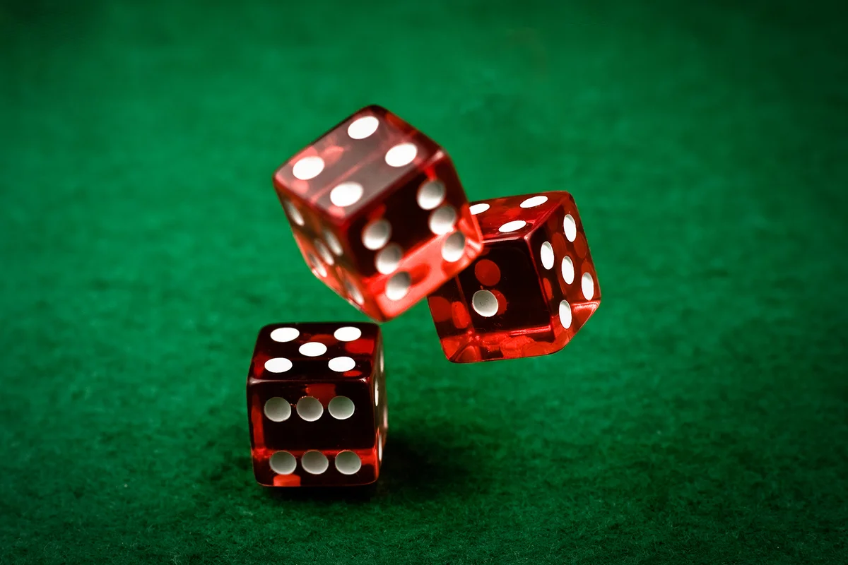 Rolling red dices on a green casino felt