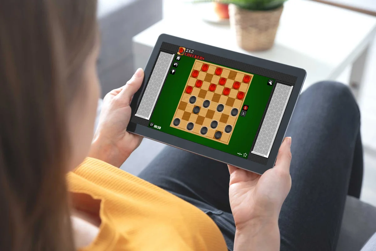 woman on tablet computer playing online checkers