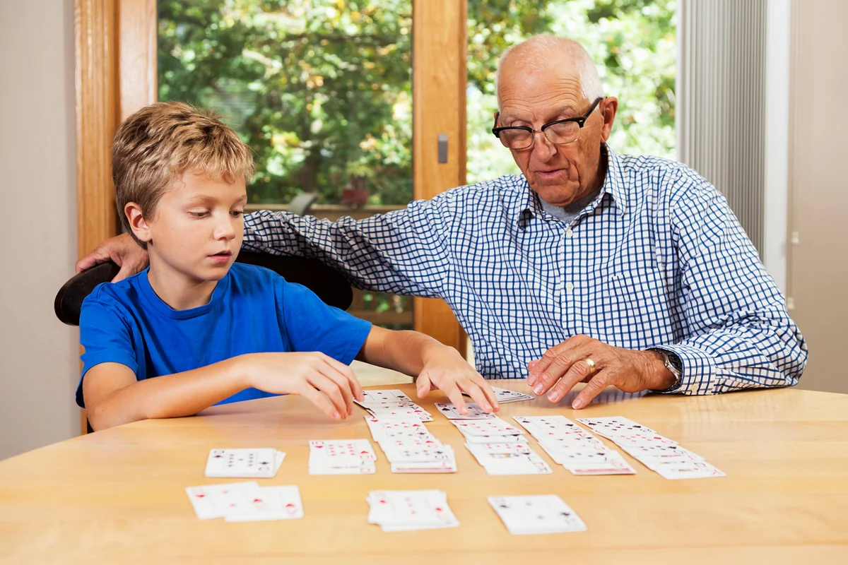Grandfather Teaching Grandson Solitaire Playing Card Game