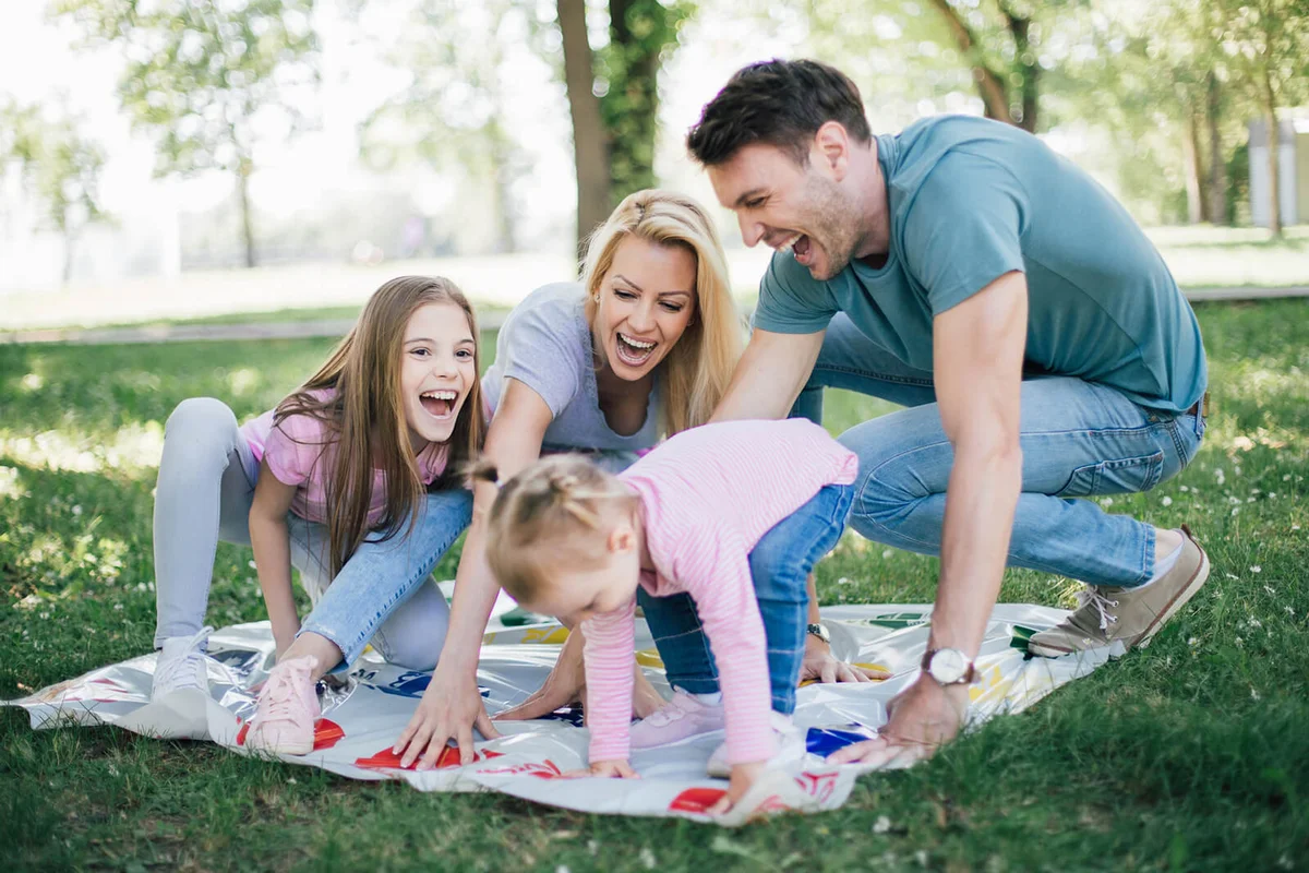 Excited family playing twister game at the park