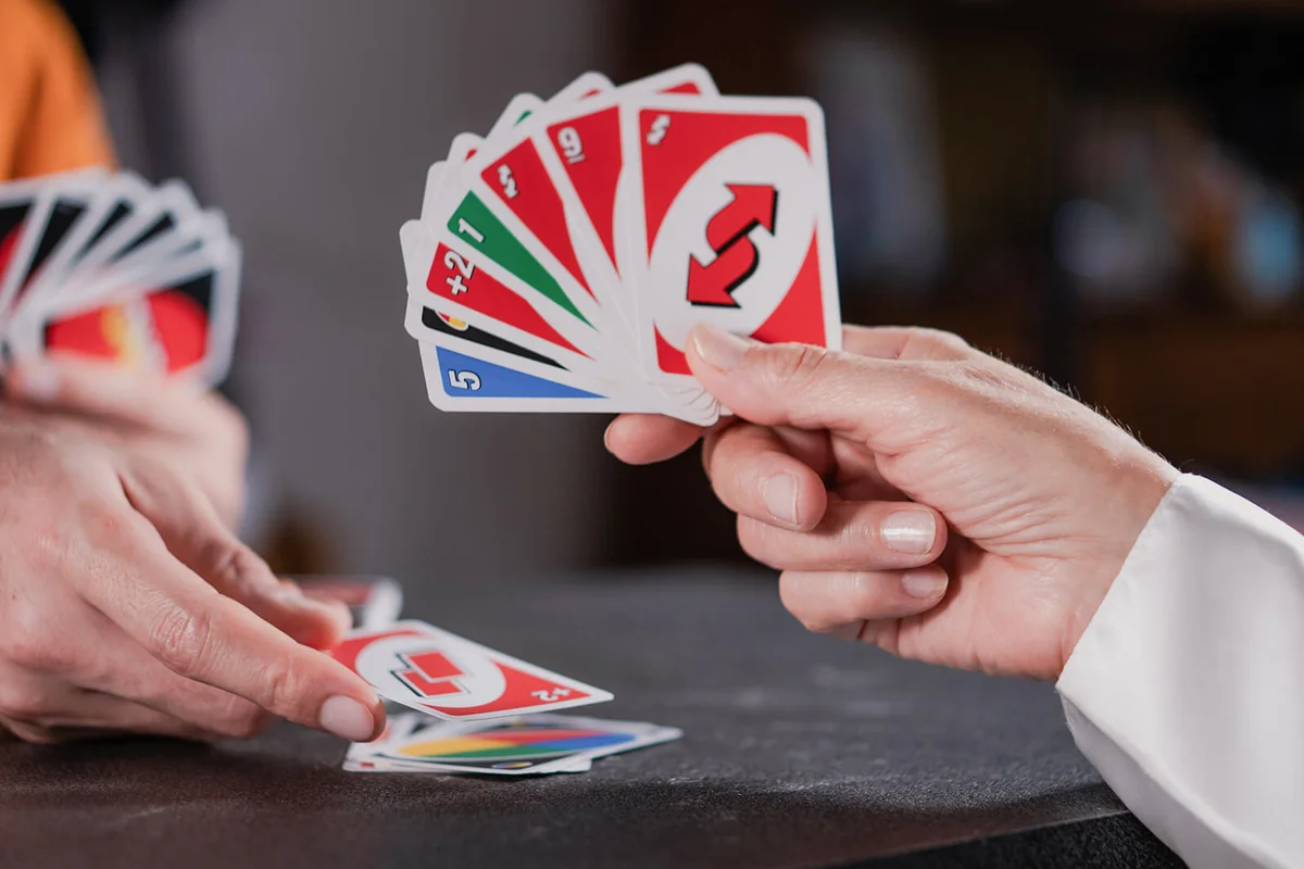 Friends playing UNO cards on a table | ID 180664349 © Eduardo Andrade | Dreamstime.com