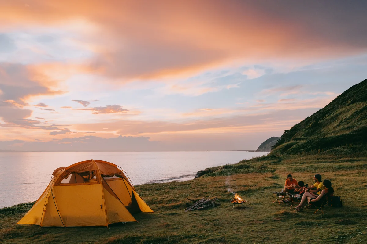 Family camping by the sea at sunset