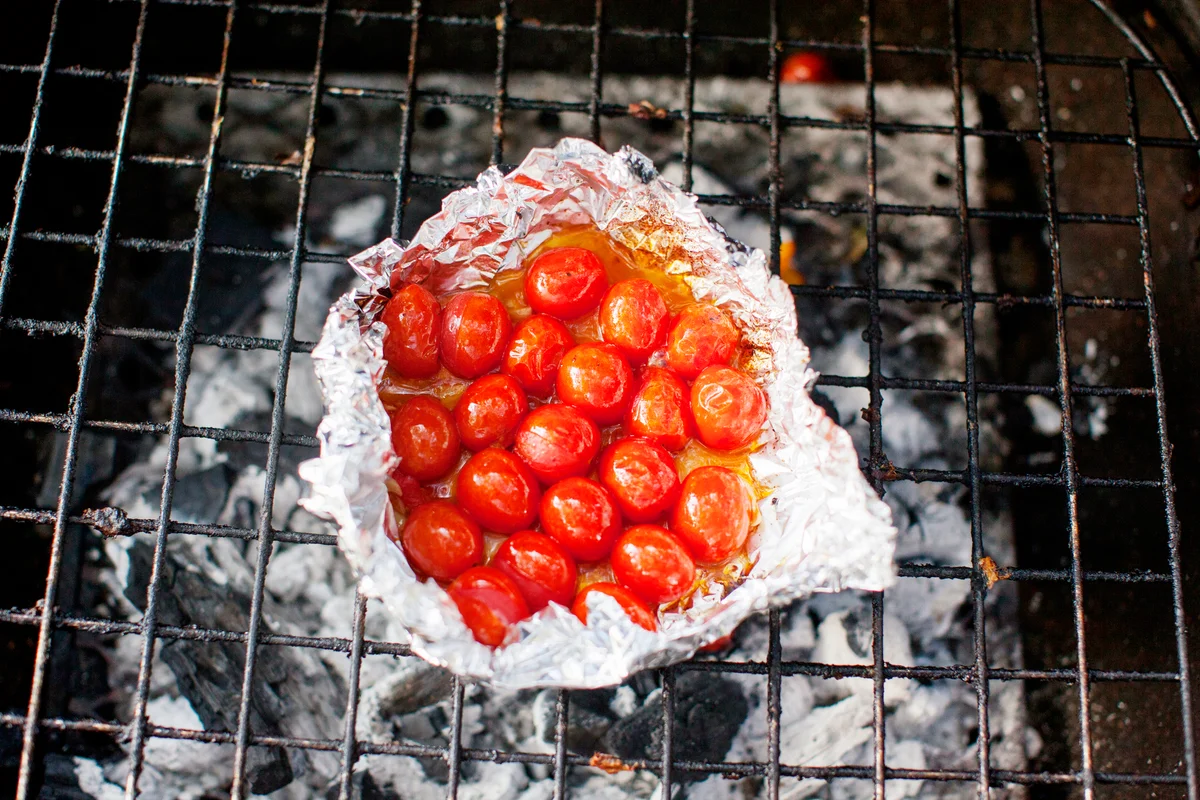 Cherry tomatoes in foil on barbecue grill