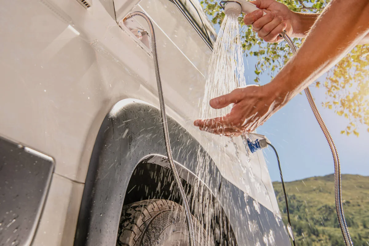 Cropped Image Of Man Washing Hands By Vehicle