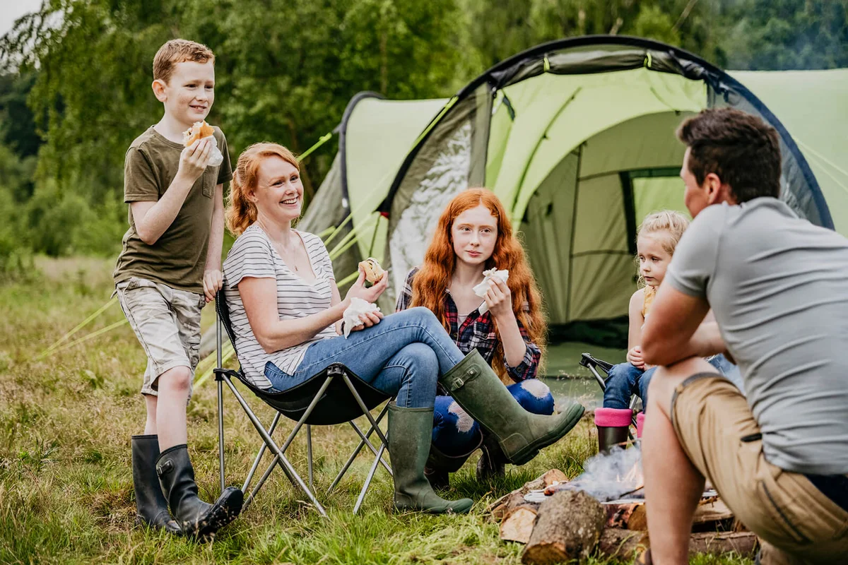 Relaxed family enjoying cookout on weekend camping trip