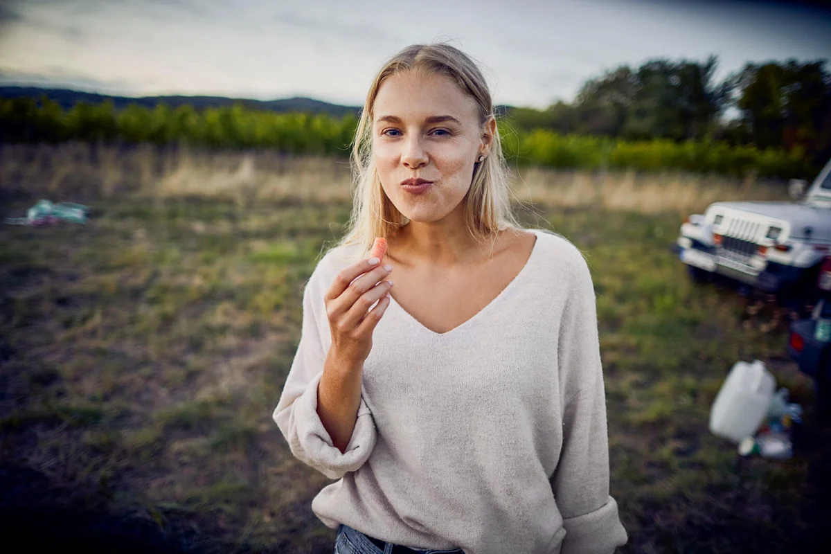 woman eating a carrot in the countryside