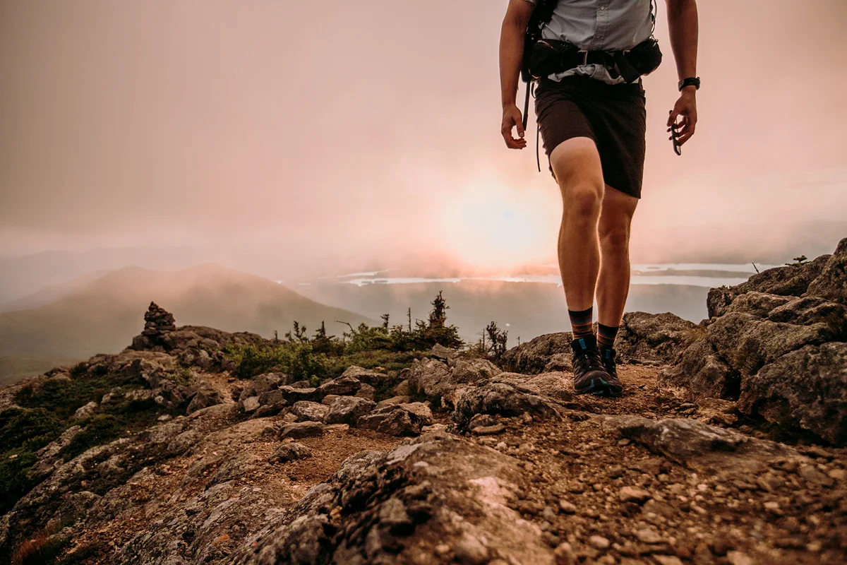 Hiker with cell phone walks along Appalachian Trail in mist