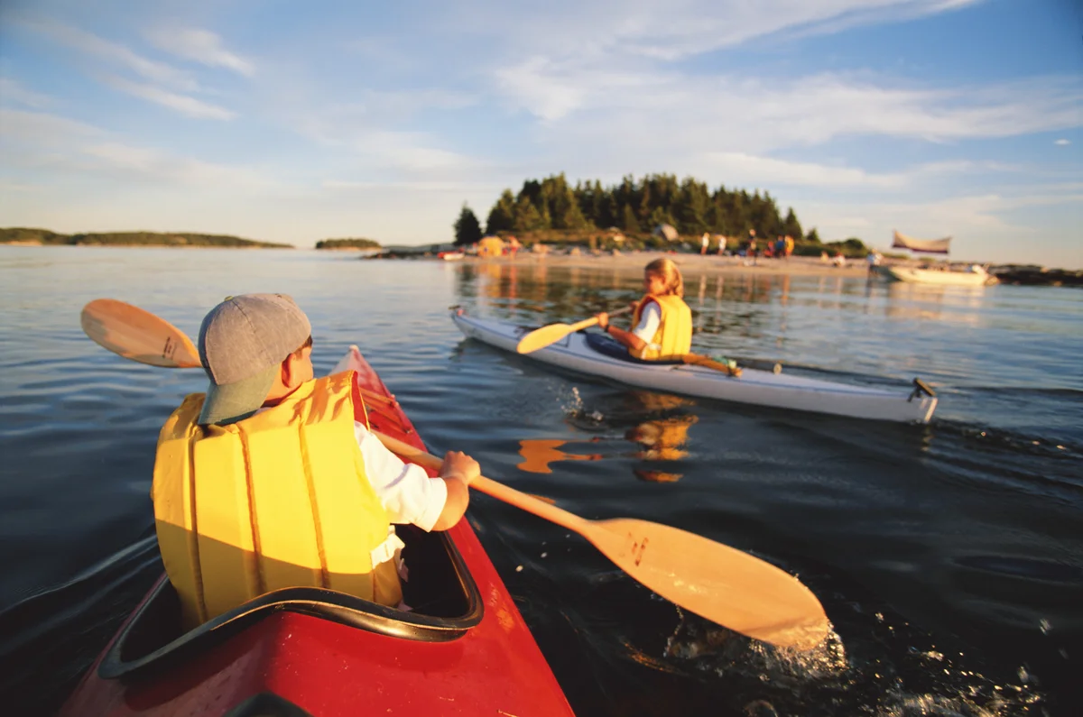 children kayaking on lake in Maine