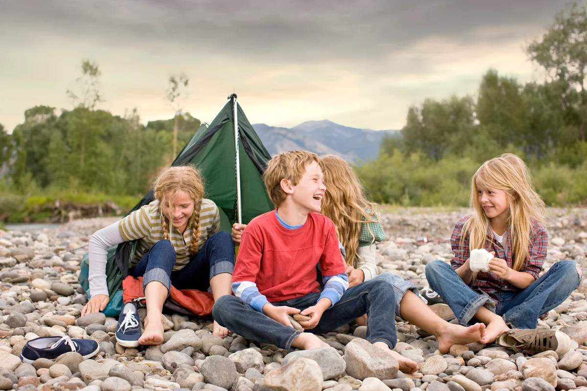 Brother and sisters playing in small tent