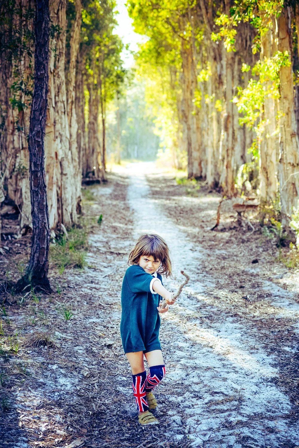 Little girl smiling and happy holds a big stick