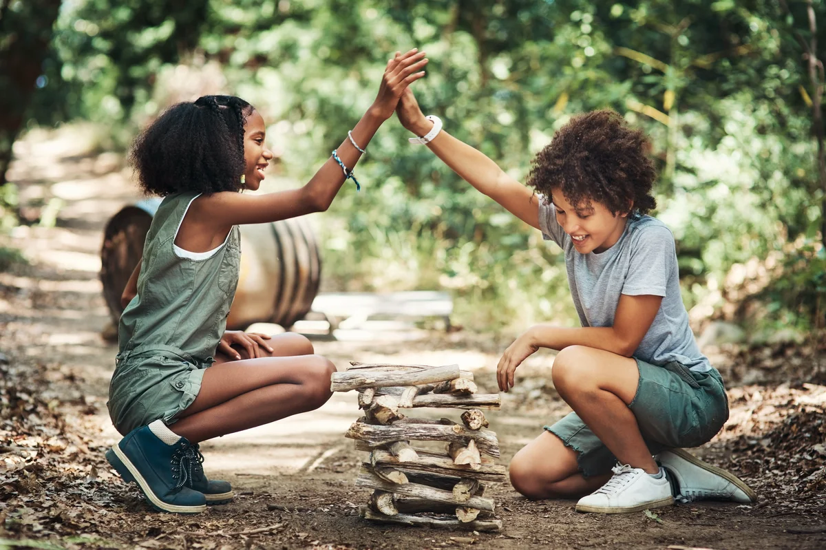 Kids building a pile of wood at summer camp