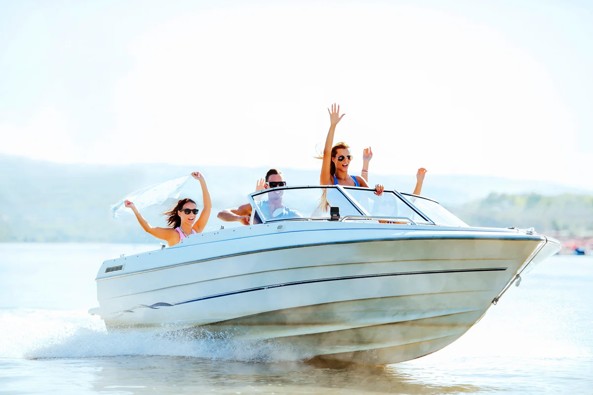 Cheerful young people riding in a speedboat