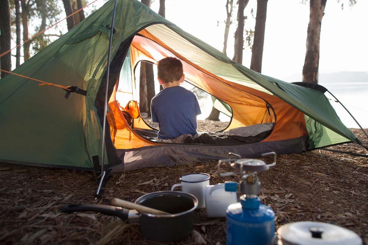 Young boy sitting alone in tent