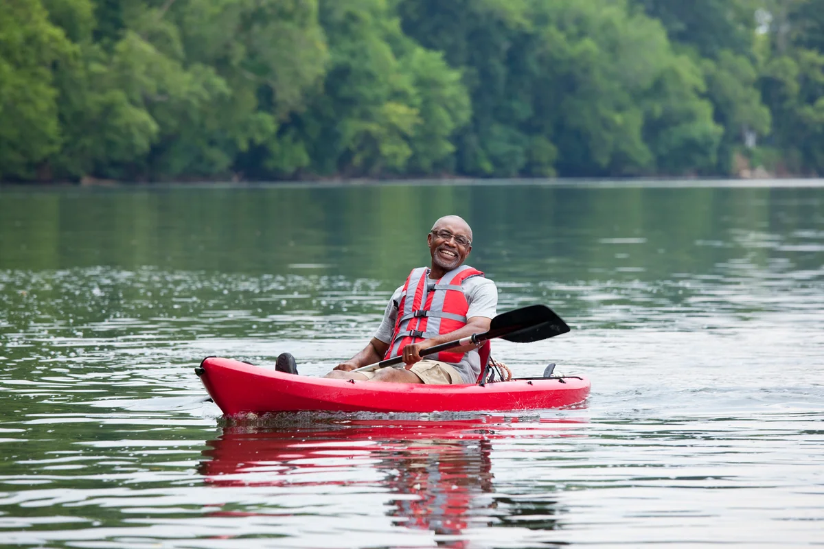 Smiling man kayaking on river
