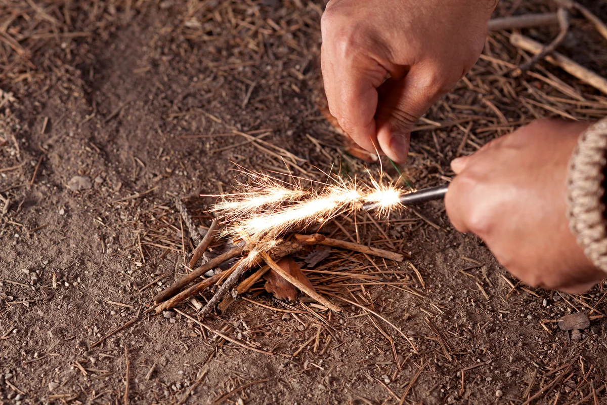 Man starting fire with ember and twigs