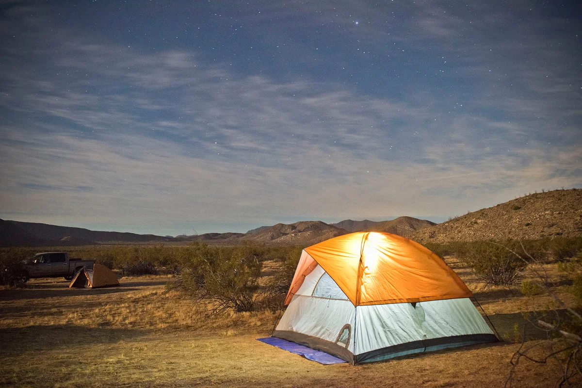 glowing tent under desert night sky