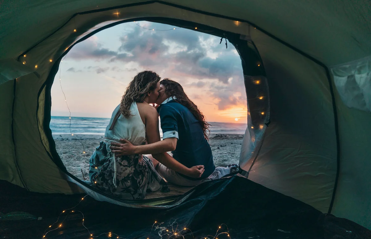 Couple admiring the sunset in a tent on the beach