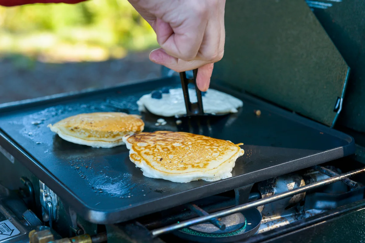 Man making pancakes at campsite