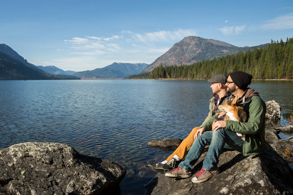 couple and their dog sit and enjoy Lake Wenatchee.