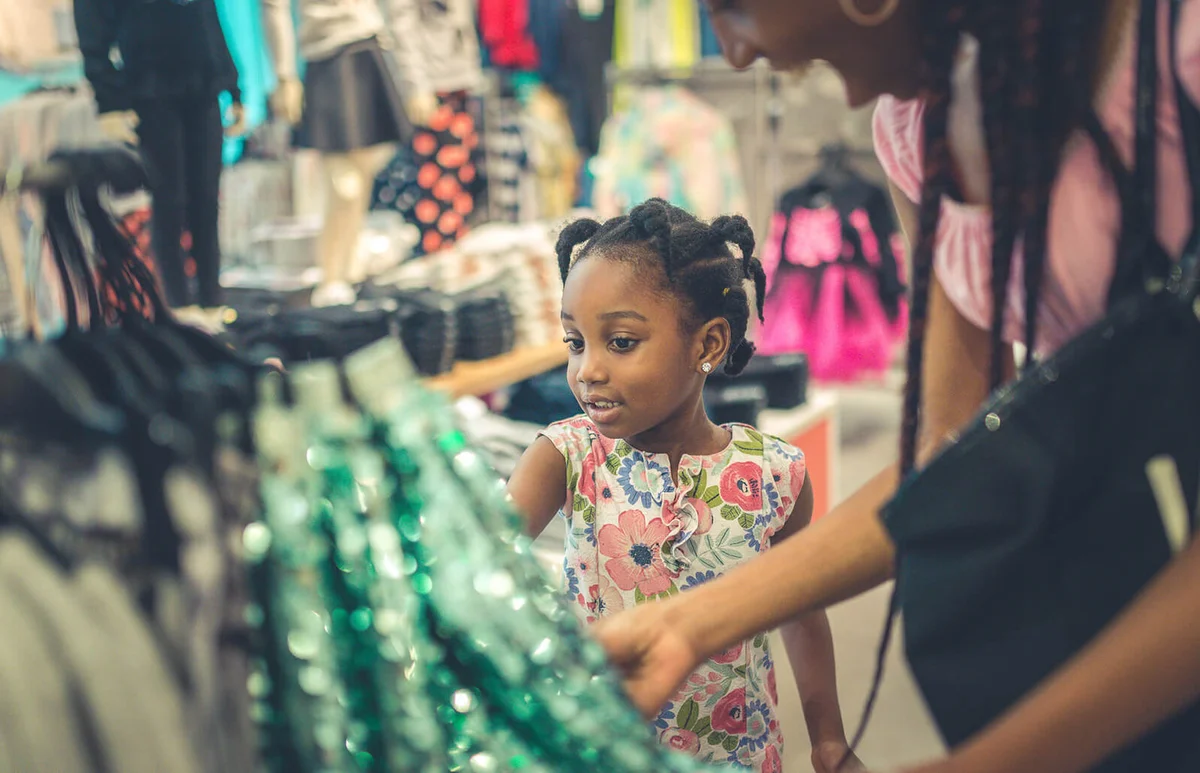 little girl and her mother shopping in a store together