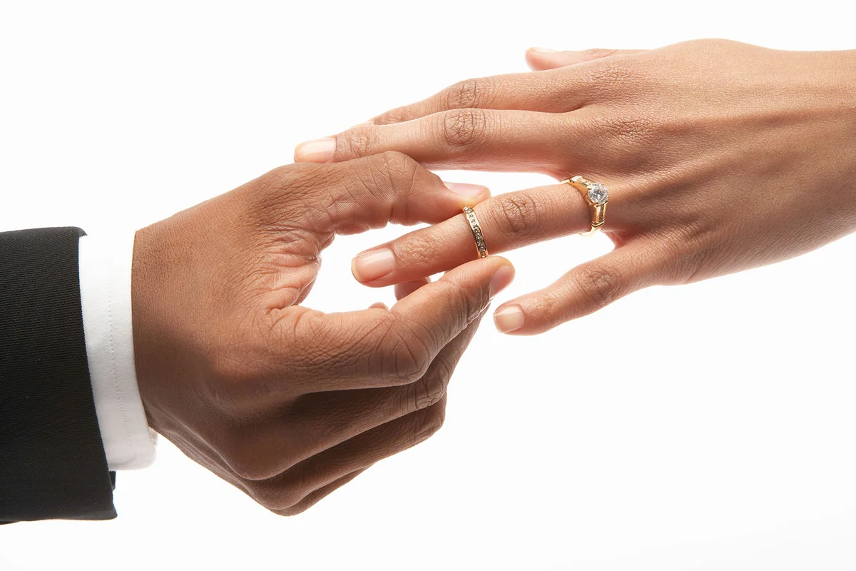 Man putting wedding ring on finger