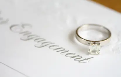 Engagement ring laying on top of an announcement
