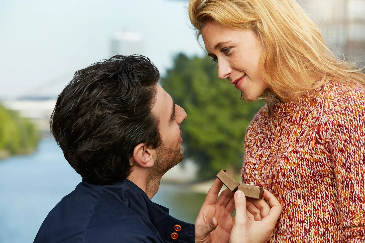 Man holding ring proposing to woman