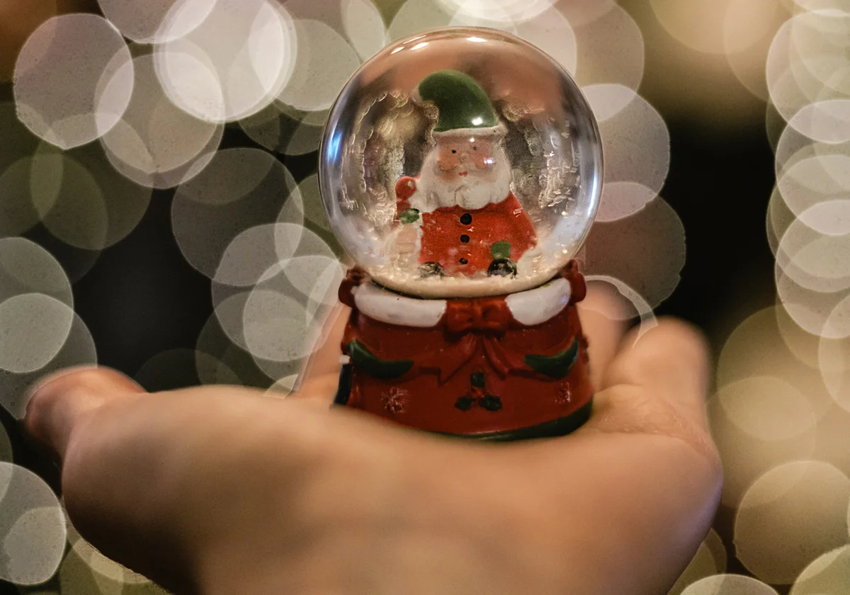 Hands holding xmas snow globe