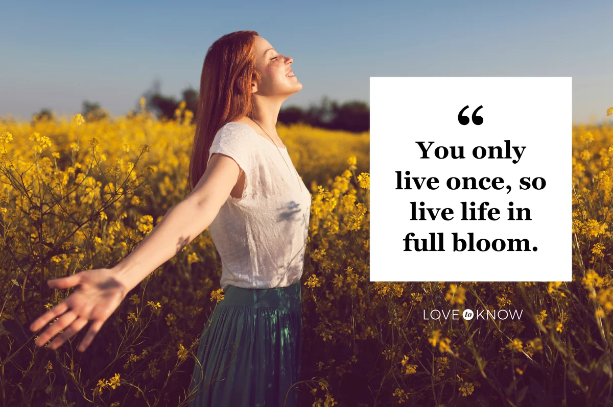 Beautiful smiling redhead enjoying a carefree spring day in a yellow flower field