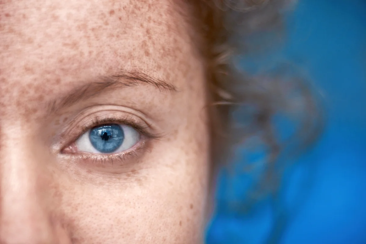 Woman with blue eyes, freckles and red hair