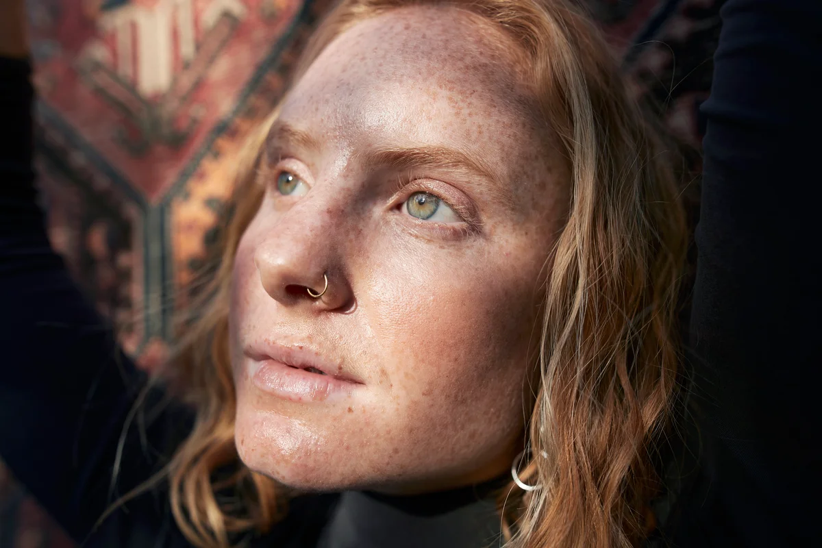 Woman with green eyes looking away in sunlight