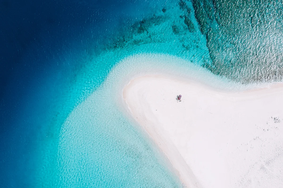 White sandbar with clear blue tropical water from above