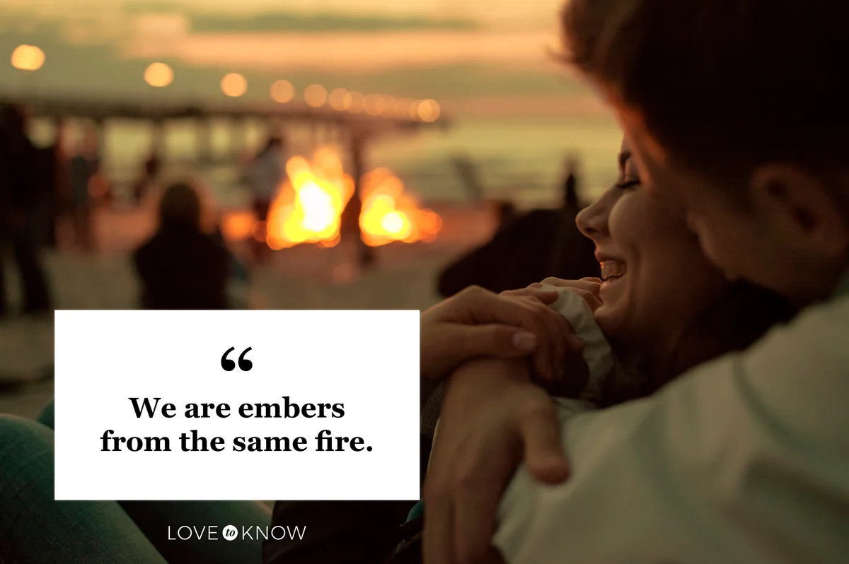 romantic couple at bonfire on beach