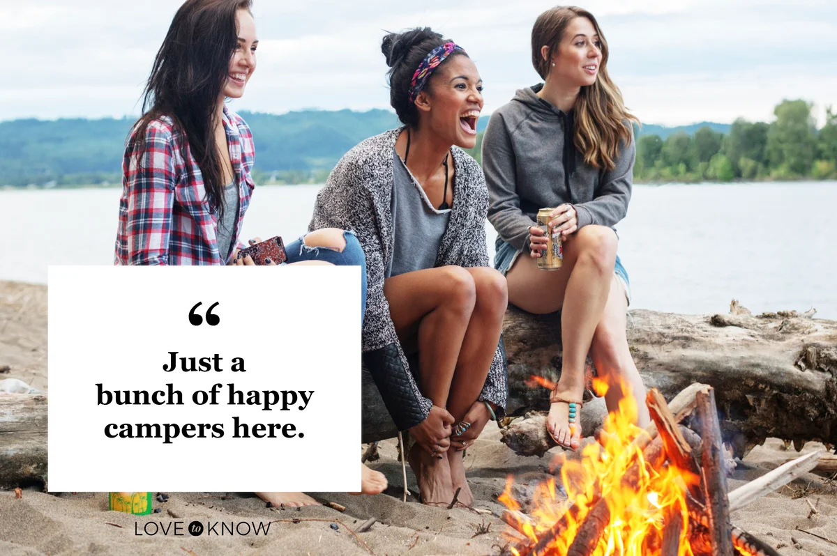 three friends women laughing having fun at campfire