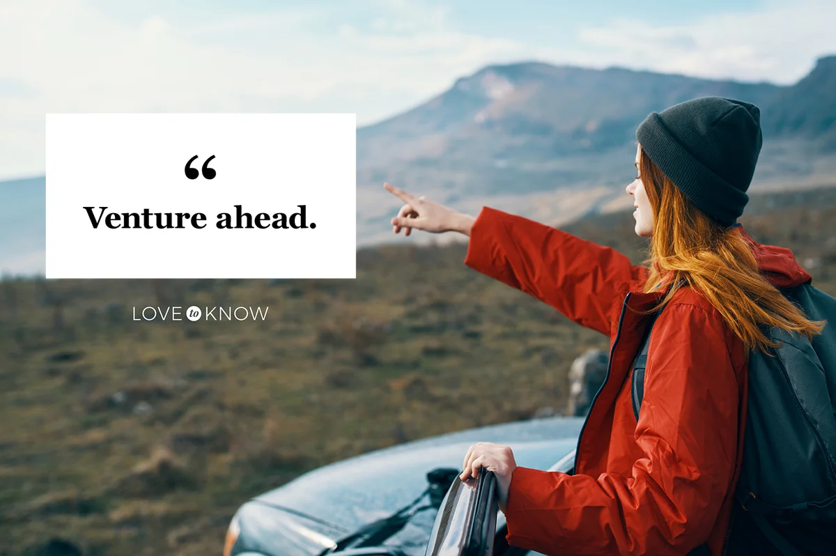 Woman in the car points her hand to the mountains